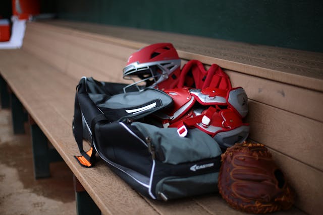 baseball helmet and glove on bench