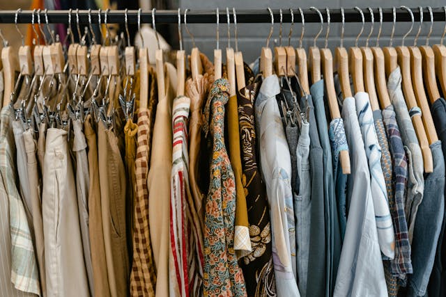 assorted clothes hanged on black steel rack