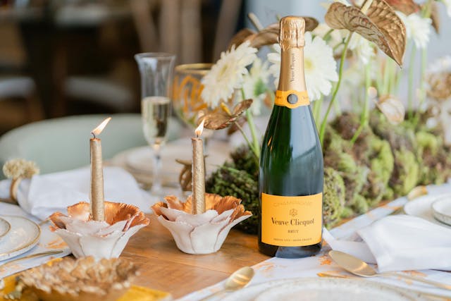 beautiful table landscape with gold candles and a bottle of champagne