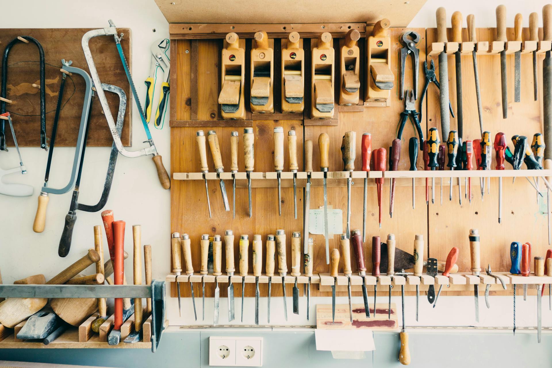 Tools organized in holders in a garage.