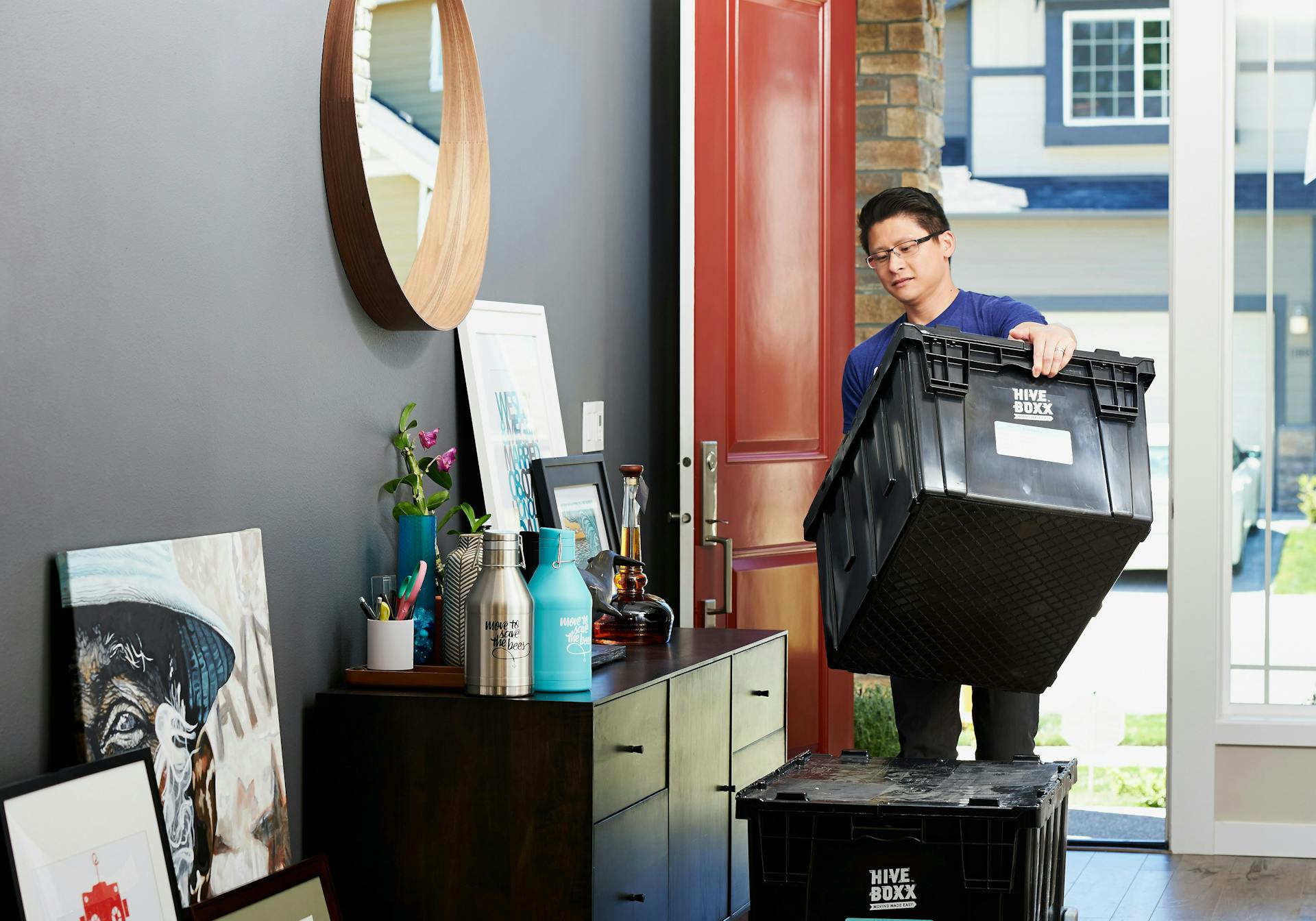 A man carrying a moving tub into his new apartment
