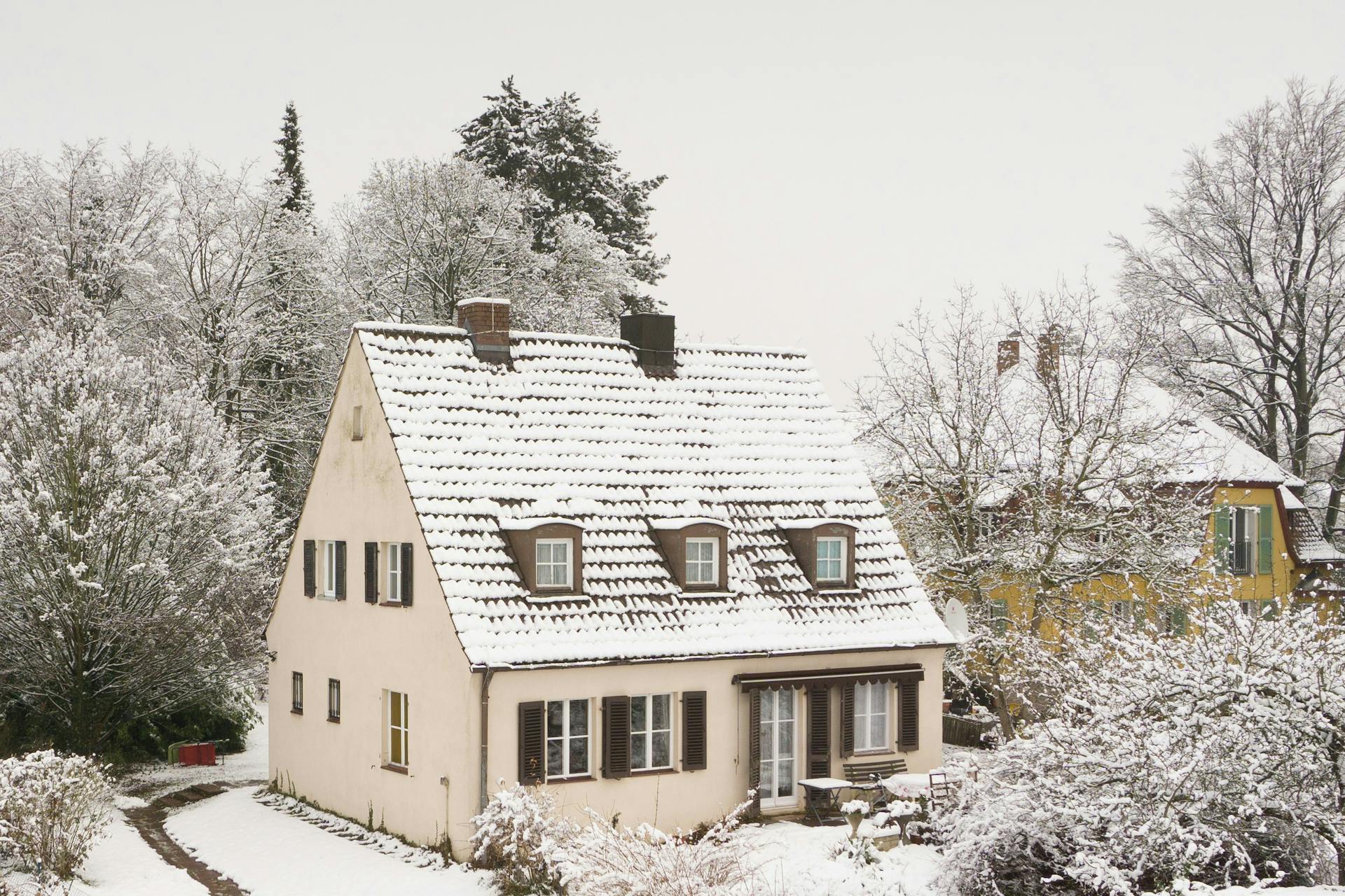 A snow-covered house in a suburban neighborhood