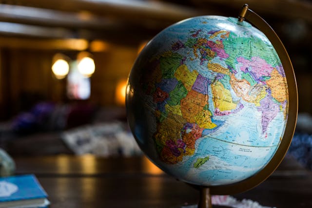 A close-up of a globe with a blurred living room in the background.}