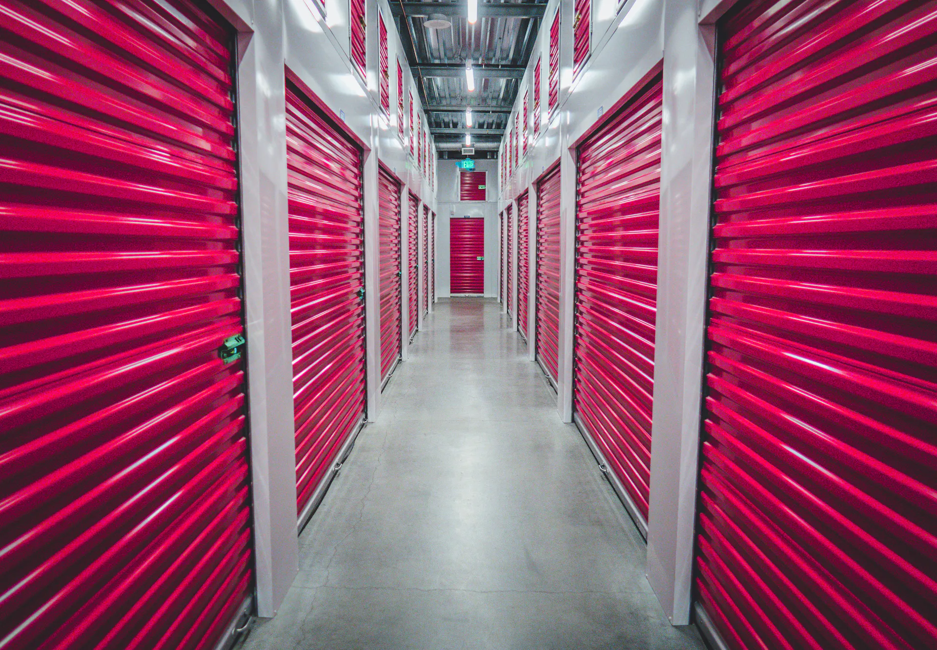 Red doors lining the interior of a climate-controlled self-storage facility.