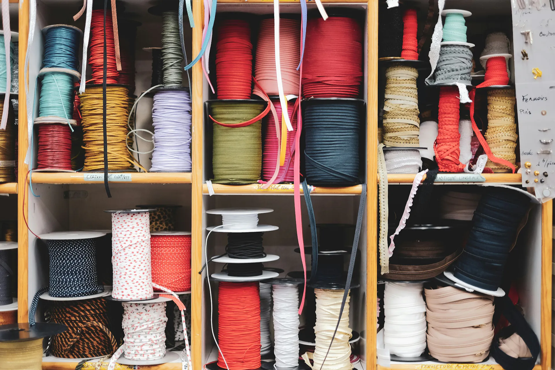 A storage drawer with various spools of thread organized for easy use.