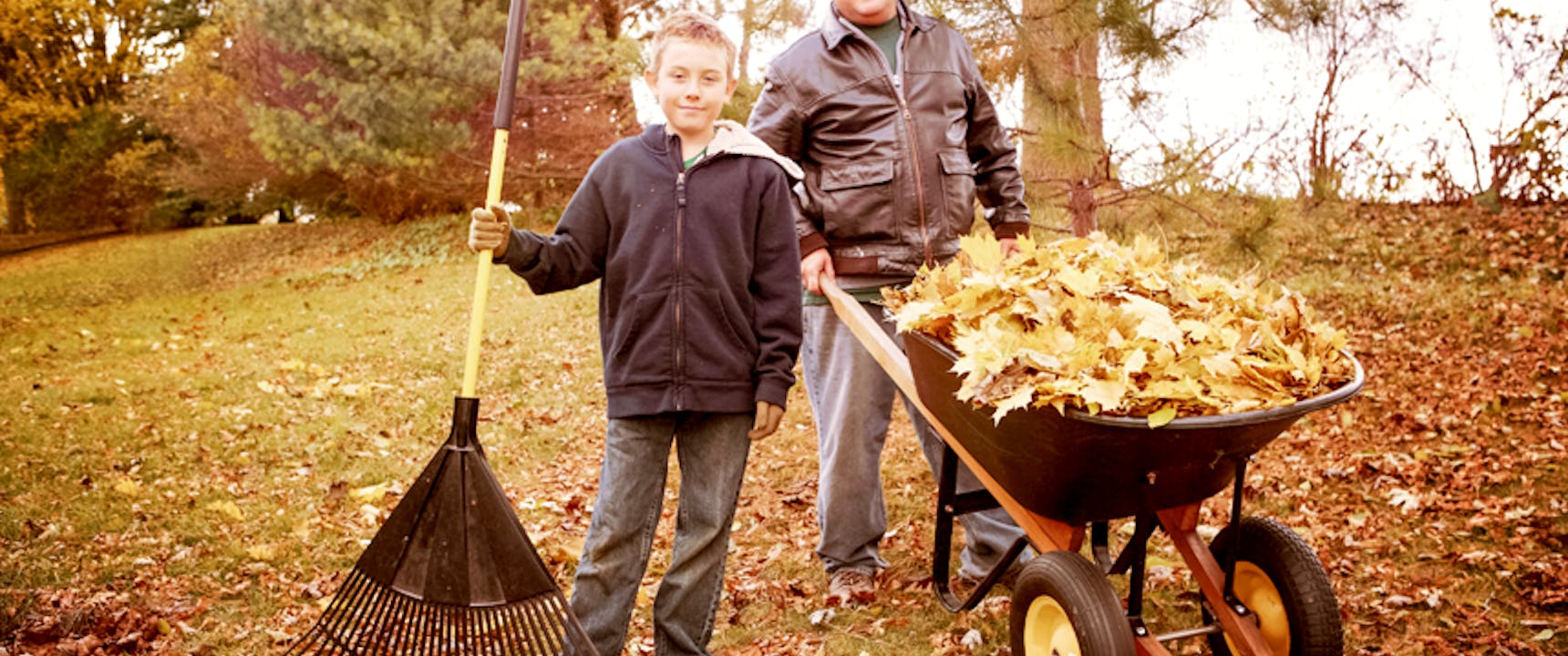 father and son raking leaves