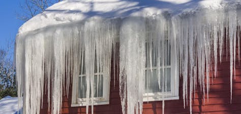 A substantial ice formation that has accumulated over time along a roof’s overhangs