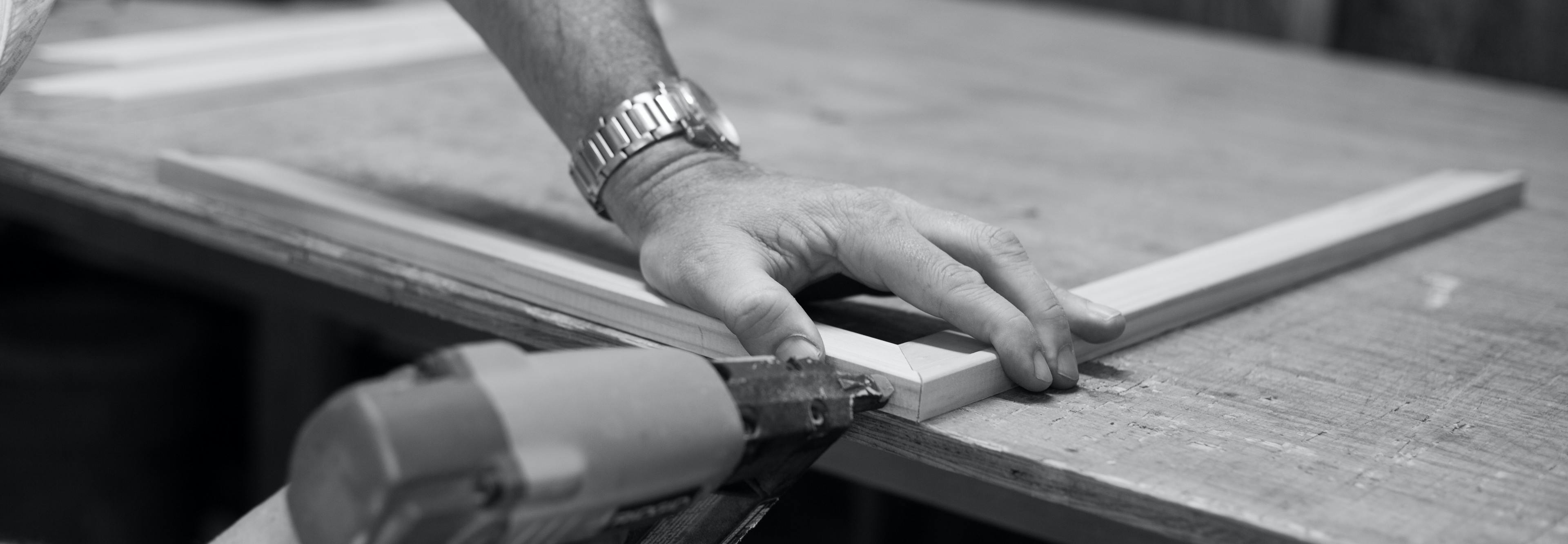 Woodworker carefully nailing a delicate frame.