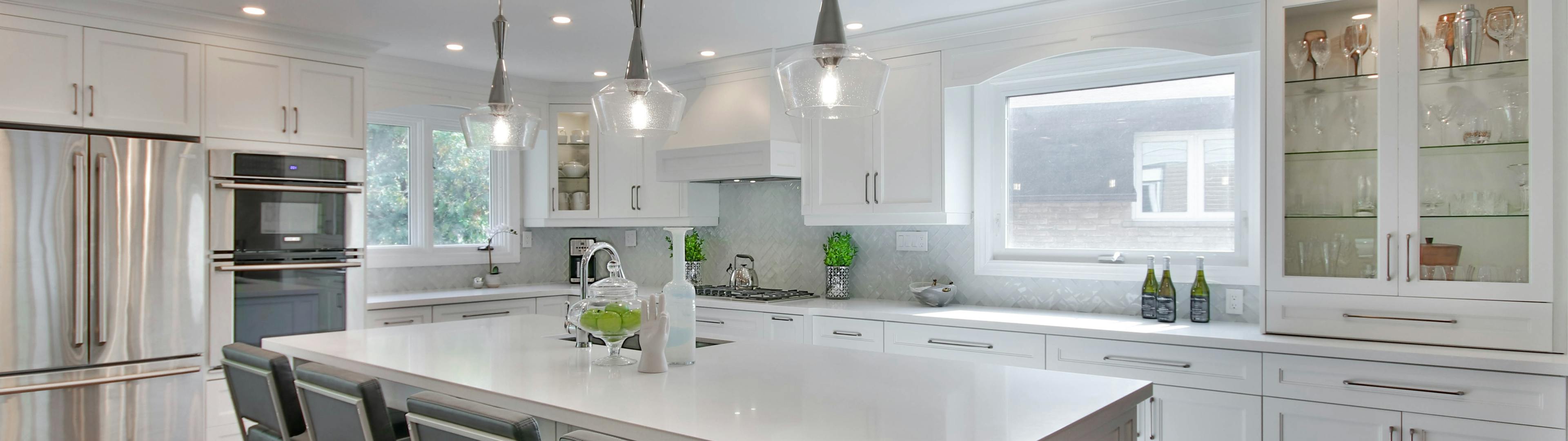 White modern kitchen, with glass cabinets, quartz bench top with island bench.