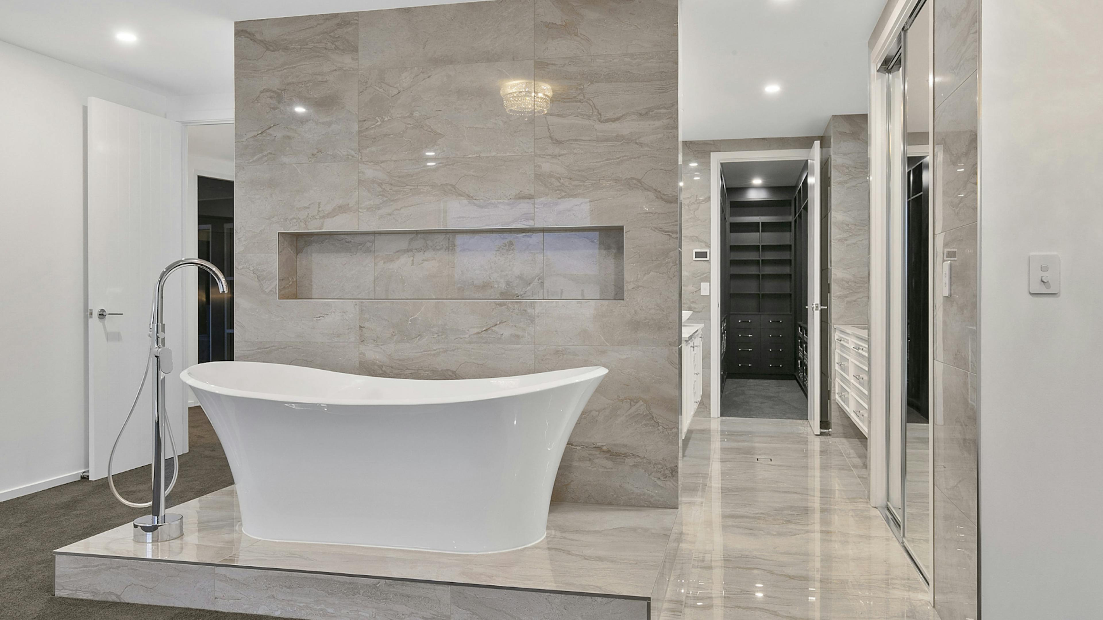 A modern, luxurious bathroom remodelling including high end bathtub done by Streamline Cabinets.