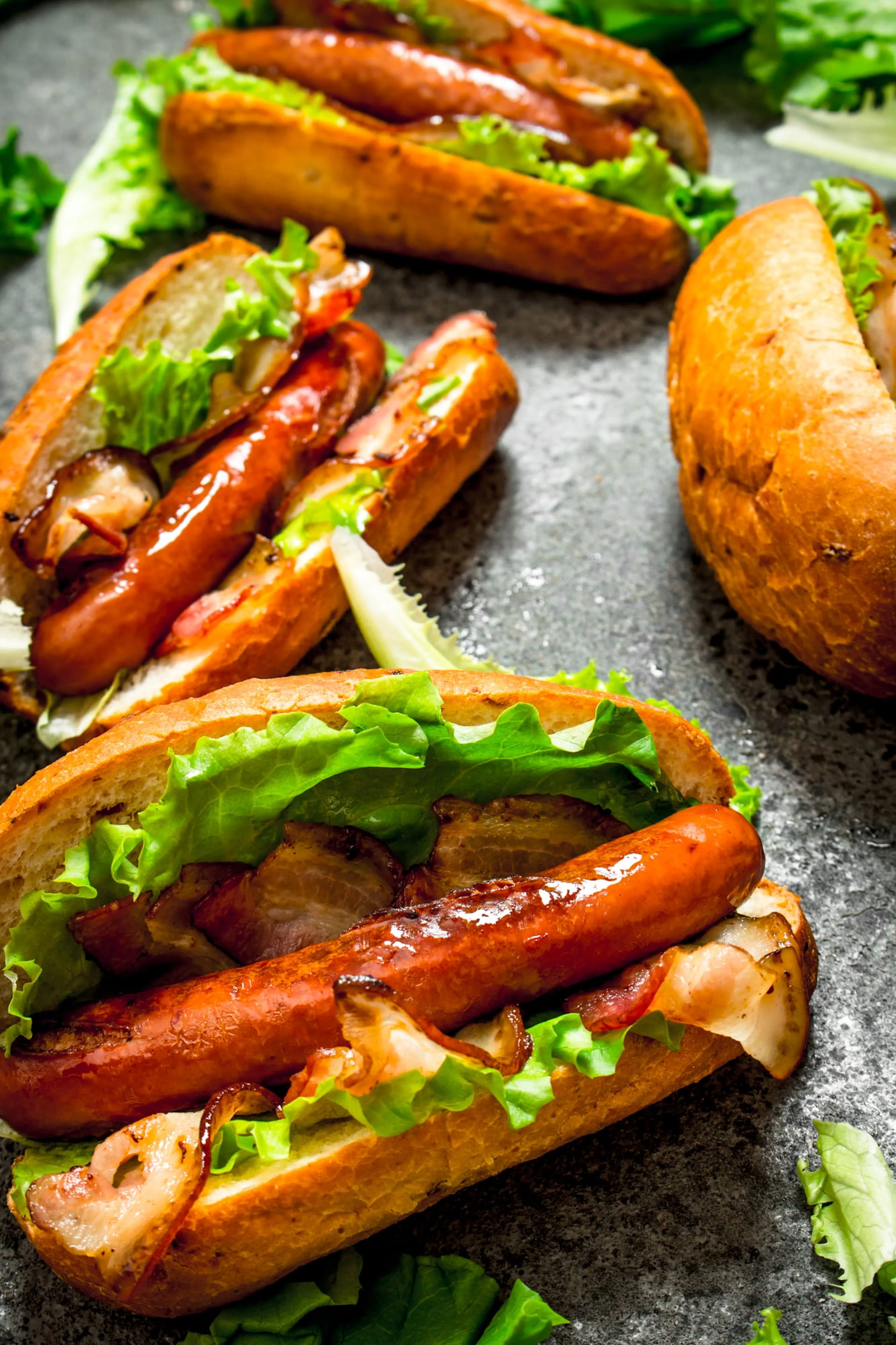 Grillad korv i bröd med bacon och sallad