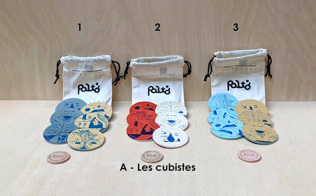 Exposition du contenu d'un sac de jeu de palets breton d'intérieur, disposant de trois variantes de couleurs basées sur la thématique des cubistes.