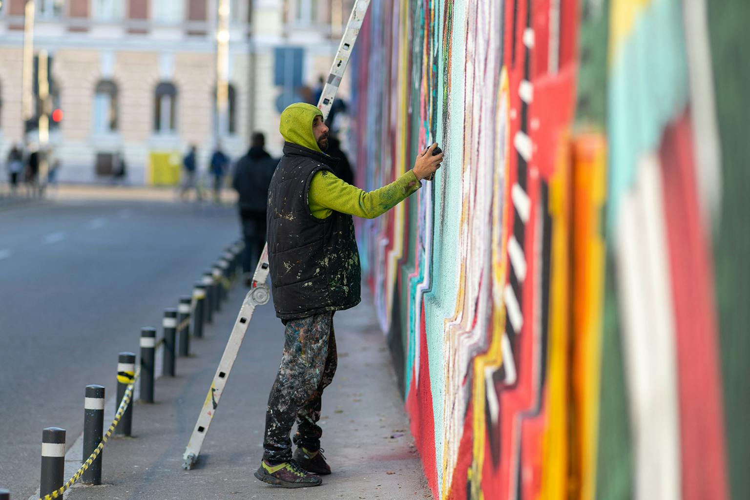 Kero, street artist roumain, peint une fresque murale à la bombe de peinture.
