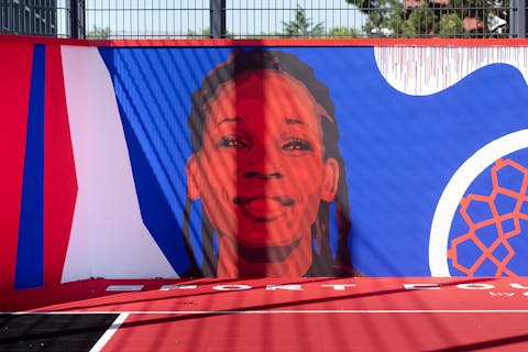 Le visage de Marielle Amant honoré par le street art sur un terrain de basketball.