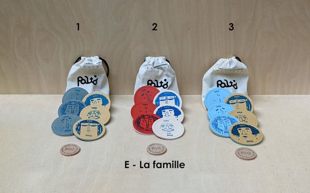 Exposition du contenu d'un sac de jeu de palets breton d'intérieur, disposant de trois variantes de couleurs basées sur la thématique des membres d'une famille.