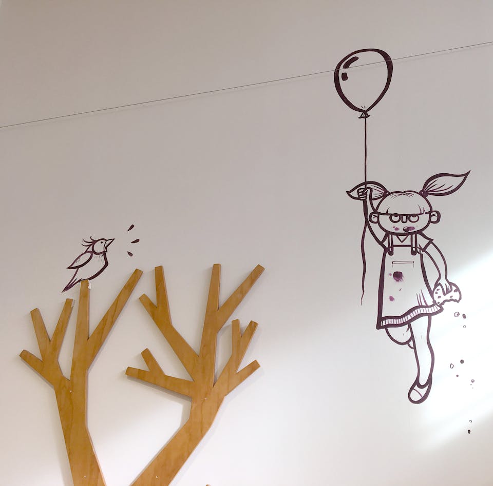 Mural art d'intérieur au cœur d'une Biocoop à Chateaubriand. L'œuvre illustre une petite fille s'envolant avec un ballon de baudruche , observée par un oisillon.