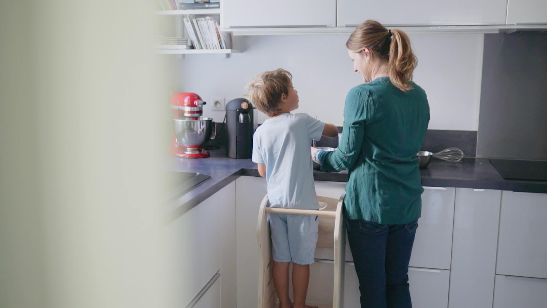 Photo d'une mère et de son enfant, cuisinant à l'aide de la tour d'observation Lol'Up.