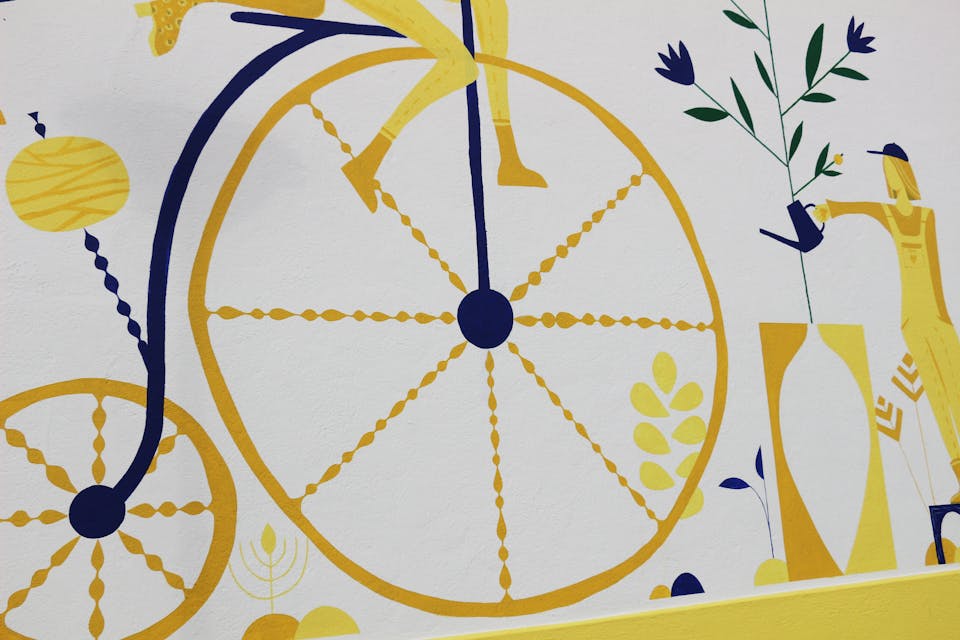 Détails de la fresque murale "Tisser du lien", illustrant une grande roue de vélo.