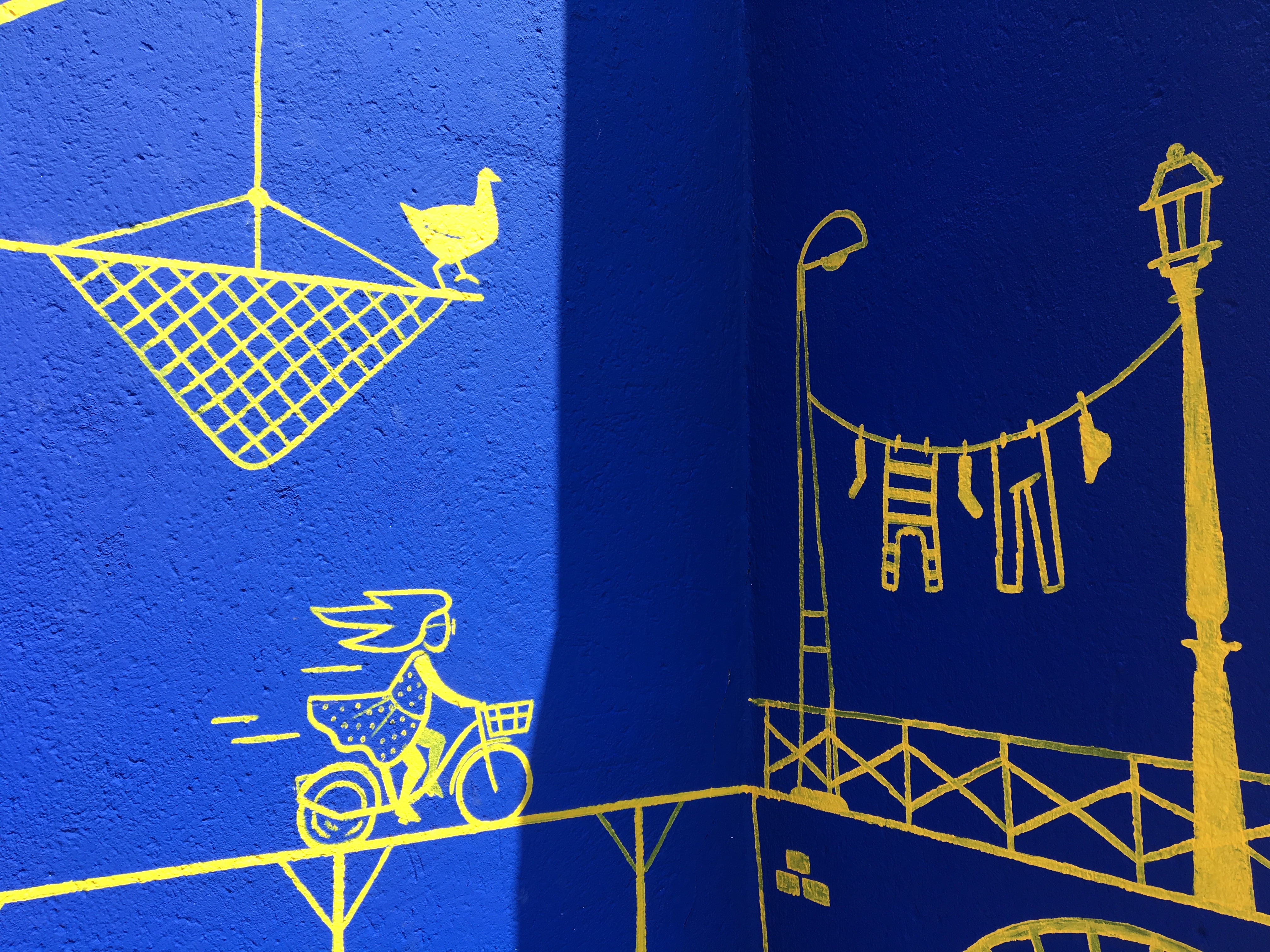 Plan rapproché d'une illustration de femme à vélo apposée sur une fresque murale extérieure à Nantes.