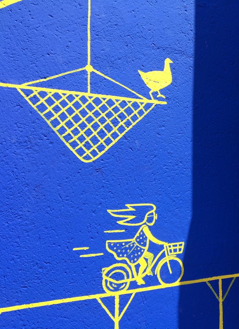 Plan rapproché d'une illustration de femme à vélo apposée sur la fresque murale rue Biesse Nantes.