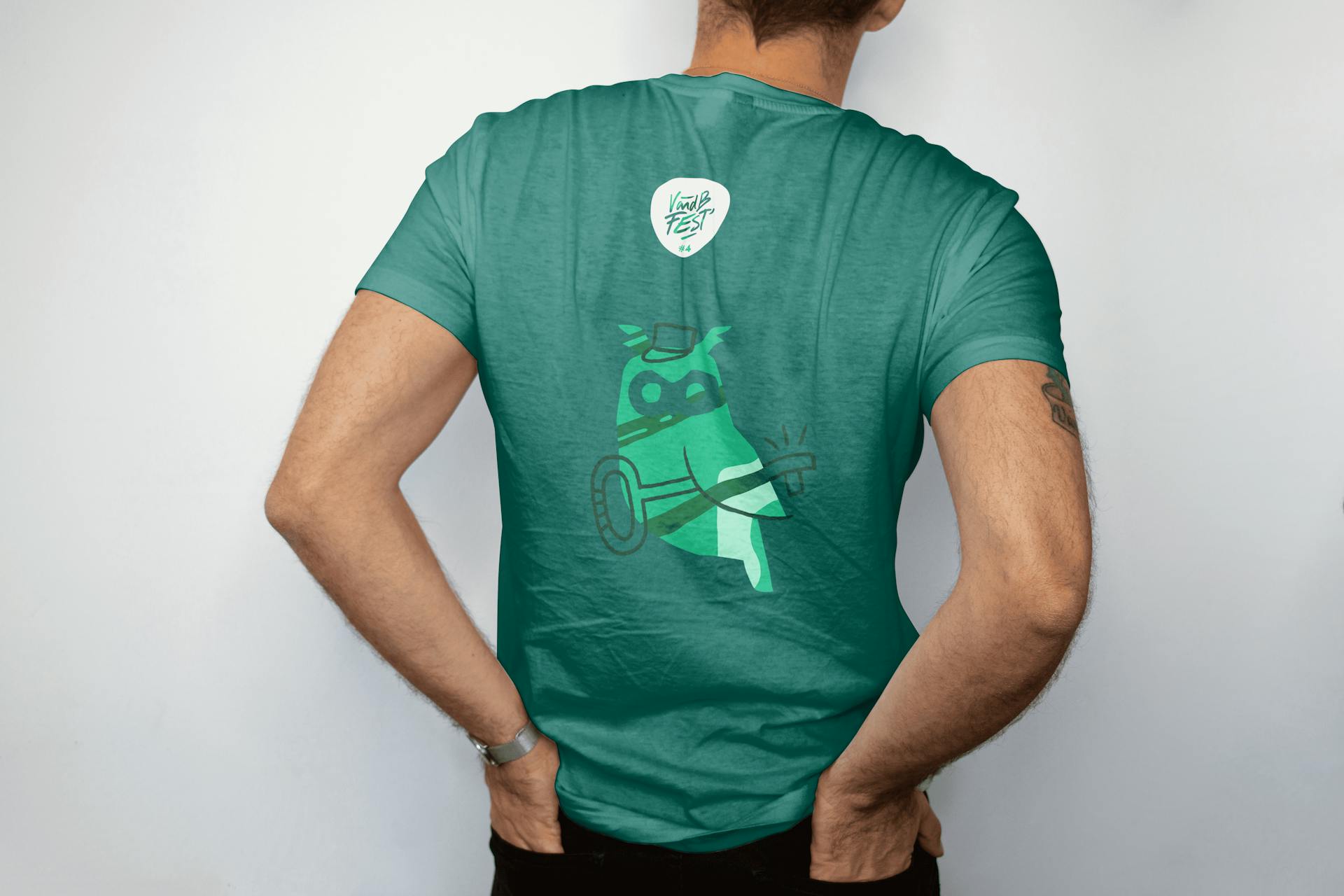 Une personne de dos portant un t-shirt aux couleurs du V and B Fest 2024 avec un dessin de chouette tenant une clé.