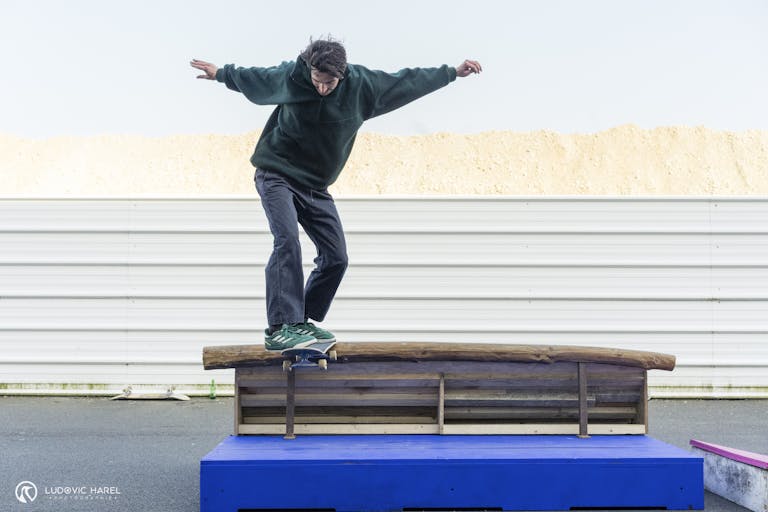 Skateur glissant sur une rampe de bois.