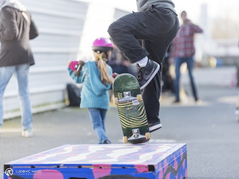 Gros plan sur la planche de skateboard d'un skateur, s'élançant sur un module de skate.