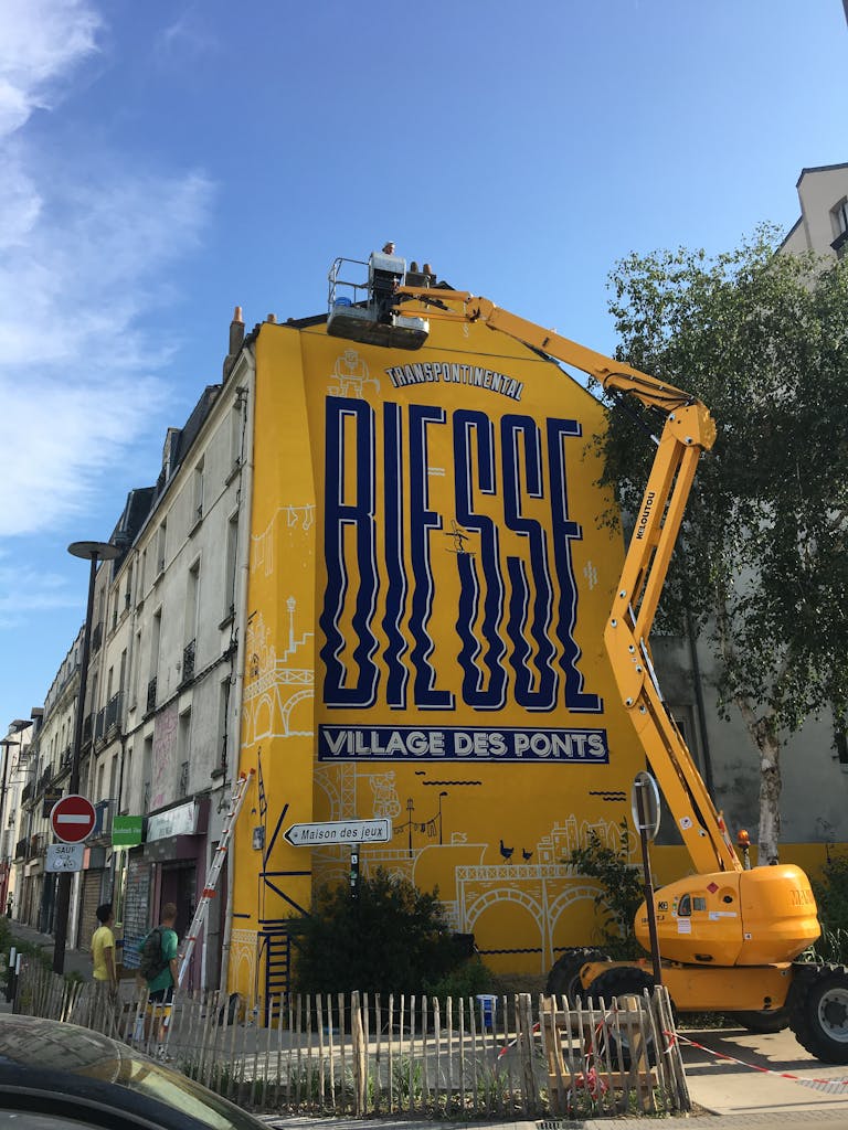 Street Art élévation d'une nacelle lors de la peinture d'un bâtiment rue Biesse Nantes.