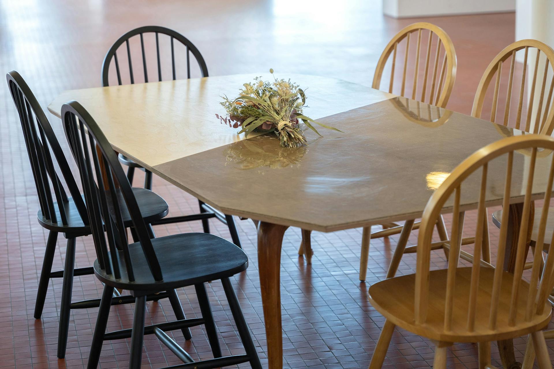 Une table en bois accompagnée de chaise issues de la scénographie de Labo Diva.