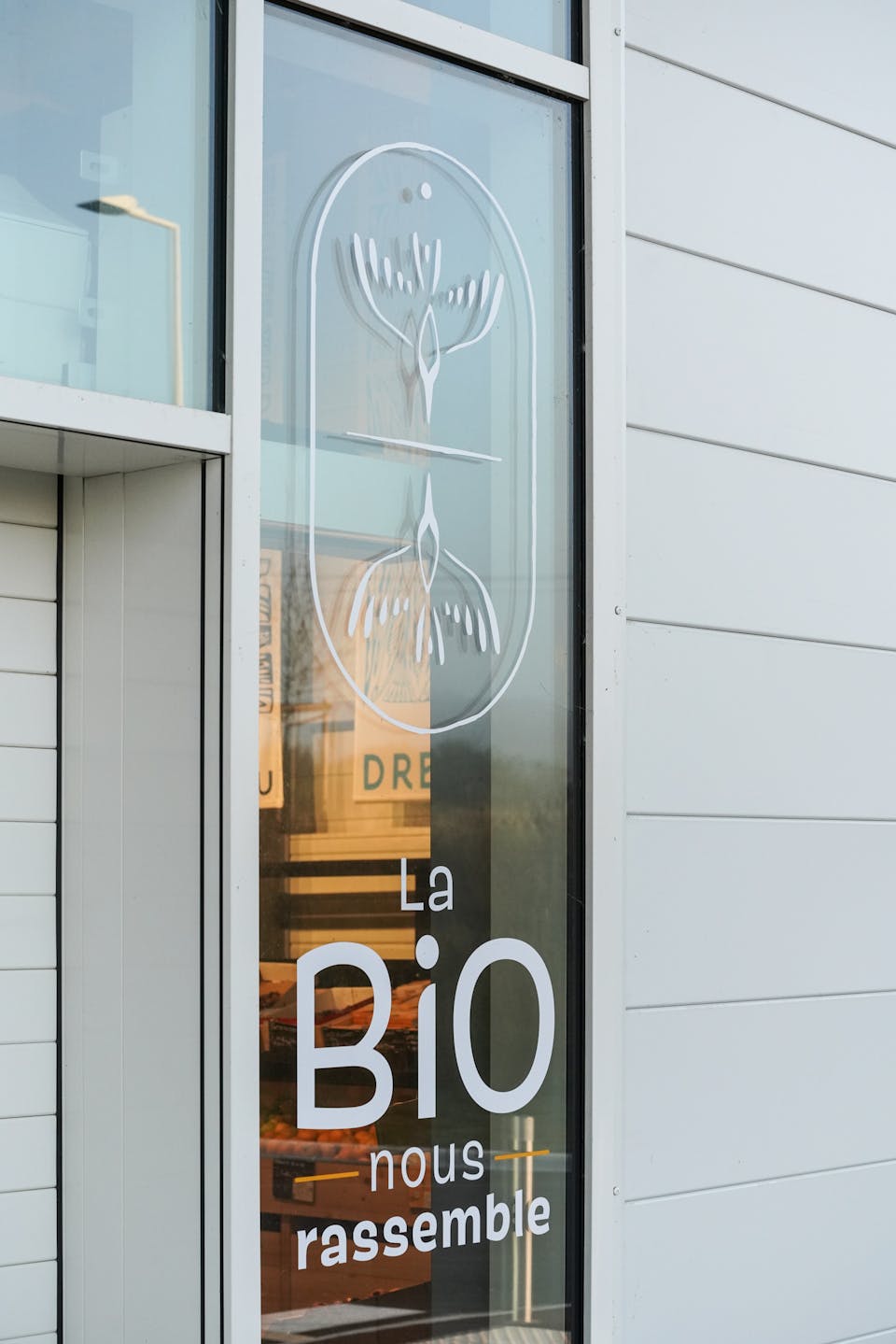 Vitrophanie du Brivet Bio à Saint-Anne sur Brivet, mise en scène du nouveau logo de l'enseigne et de la baseline Biocoop.