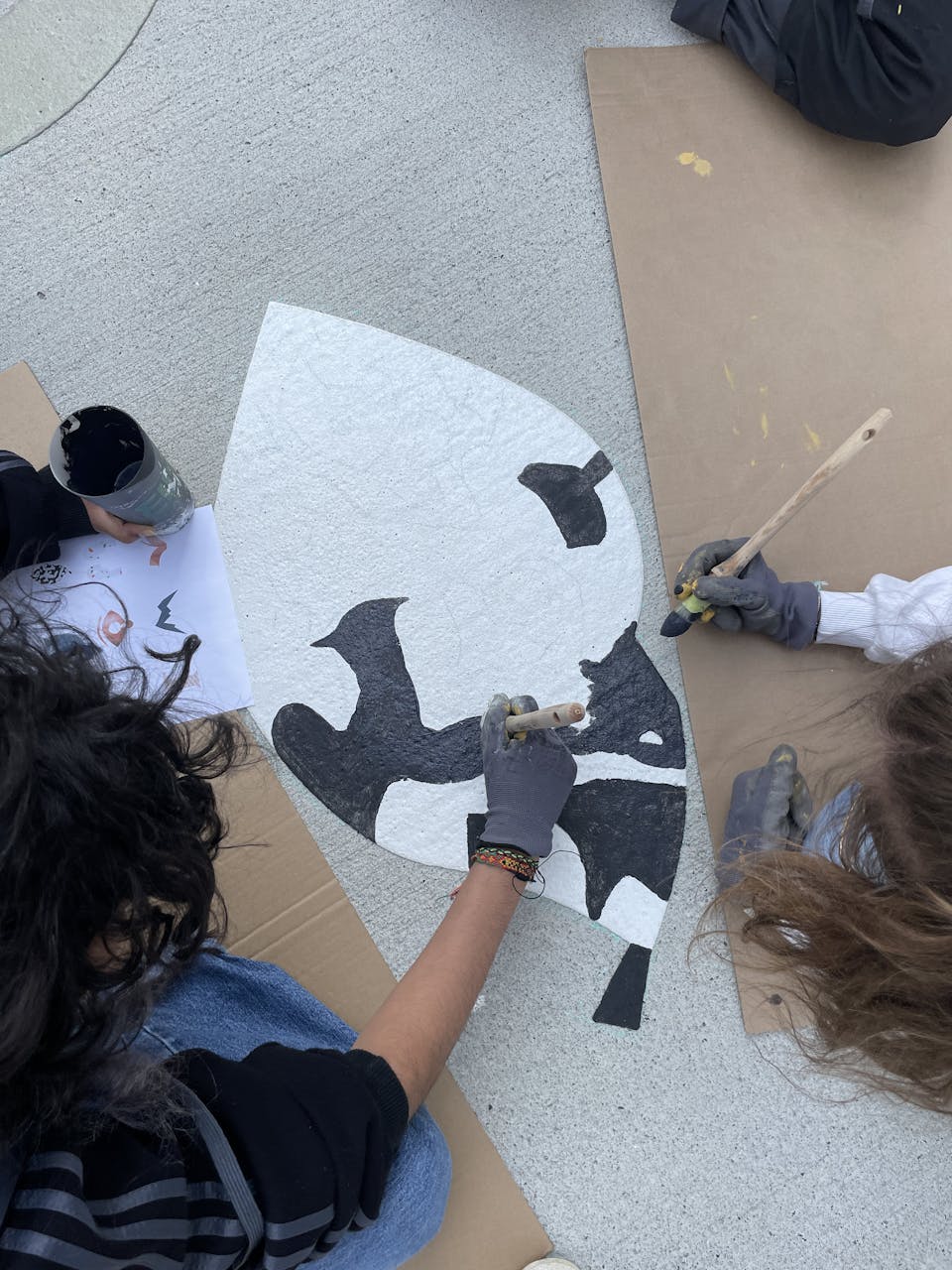 Peinture d'un glyphe en forme d'œil par les élèves de la Joliverie lors du parcours inter-écoles réalisé en collaboration avec l'agence de design Katra.