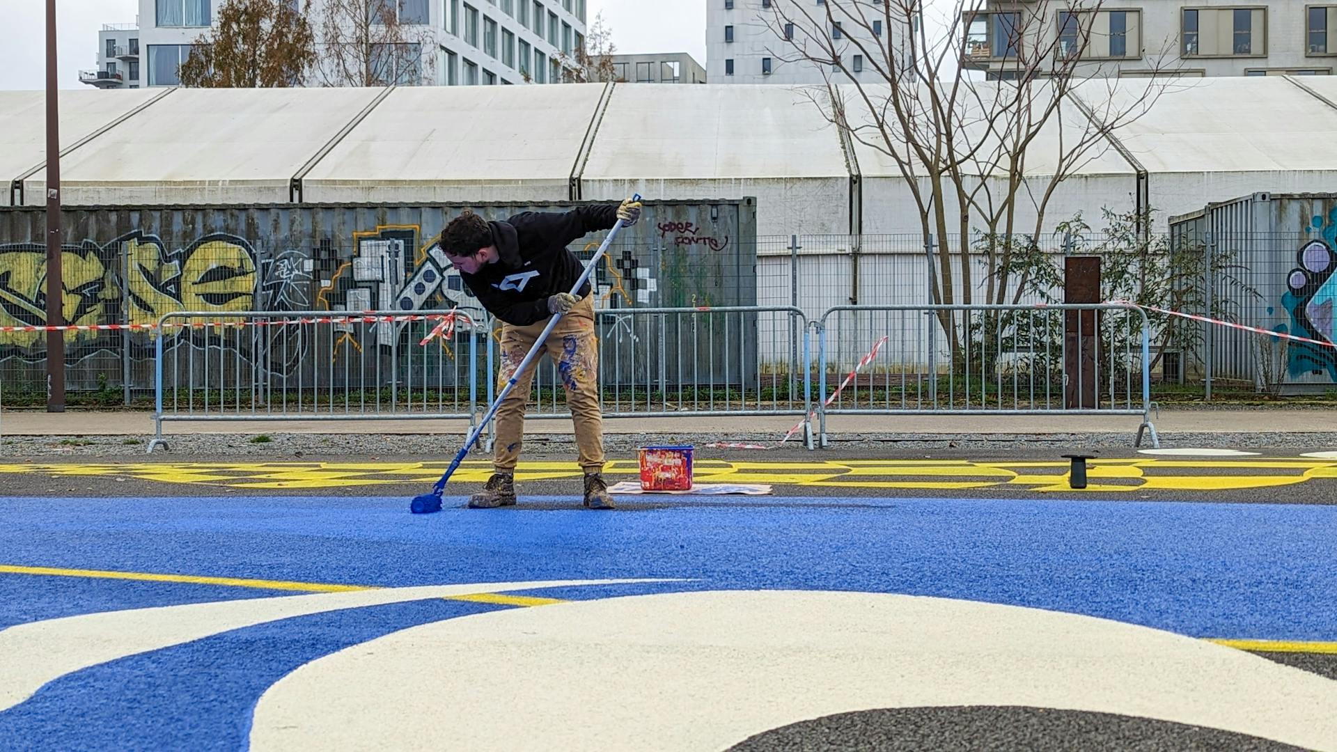 Les designers graphiques du Studio Katra peignent le nouvel espace de design actif Alice Milliat devant la Cale 2 Créateurs de l'Île de Nantes.