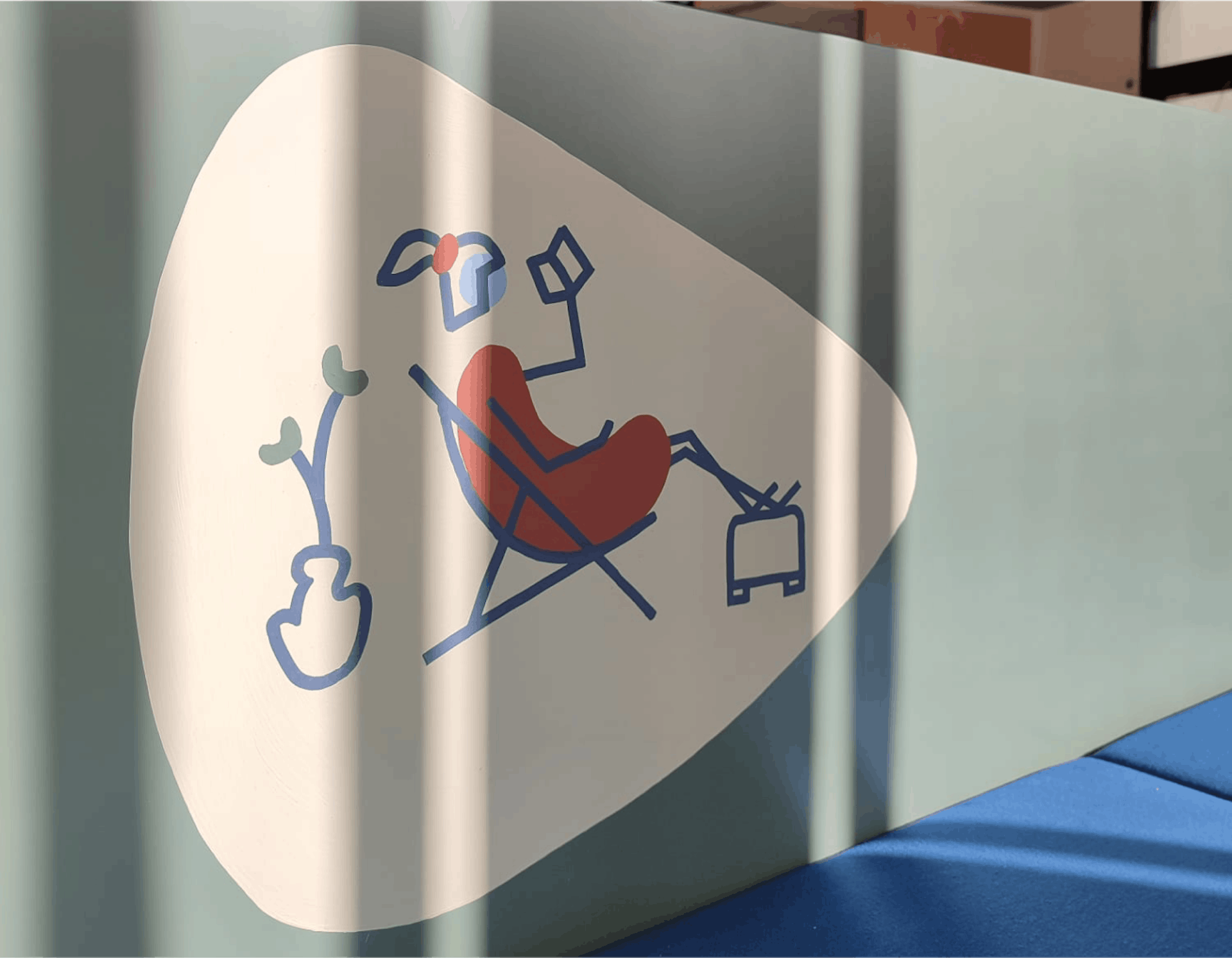 Un personnage filaire en train de lire un livre, peint sur le mobilier dédié à l'aménagement intérieur des nouveaux locaux de la CCI Saint-Nazaire, réalisé par l'agence de design Studio Katra.