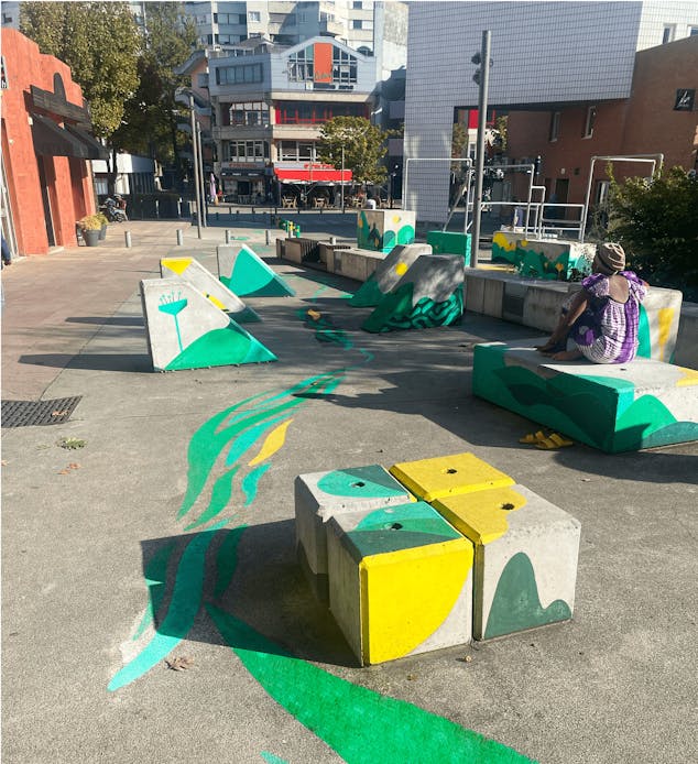 La Cool&Verte, une peinture au sol circulant entre des blocs béton dédiés à l'Art du Déplacement à Evry-Courcouronnes.