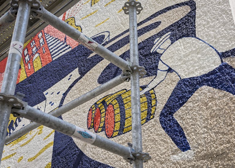 Zoom sur une peinture murale du Studio Katra illustrant un marin qui pousse des tonneaux sur les quais de la Fosse.