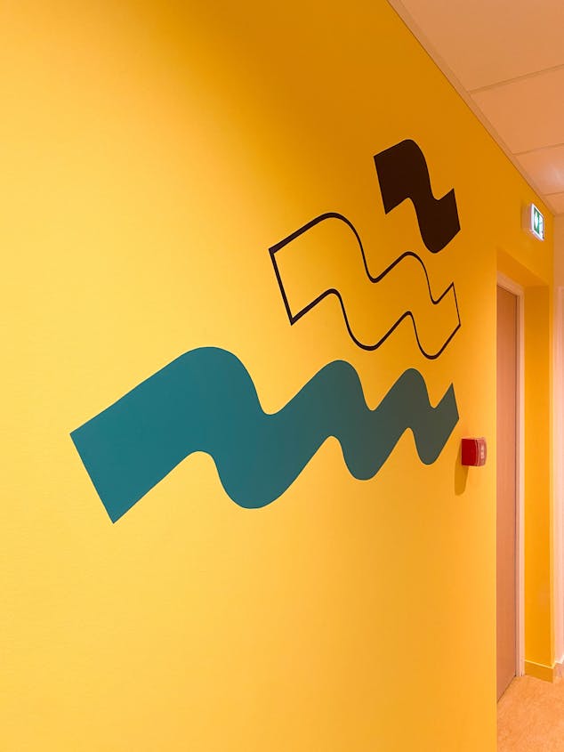 Une illustration filaire symbolisant le mouvement de l'eau, apposée par sticker dans le cadre de l'aménagement de la Maison de l'Entreprise à Saint-Nazaire par l'agence de design Studio Katra.