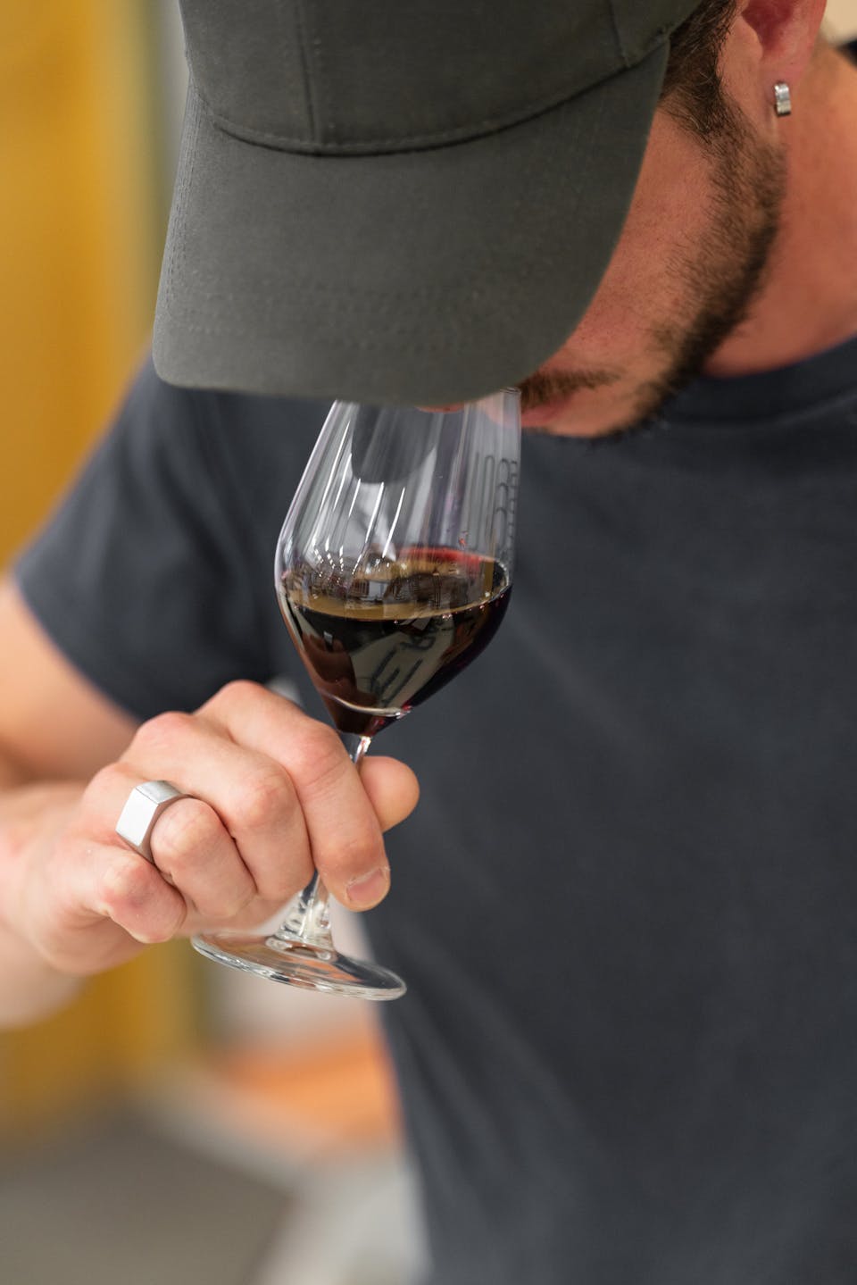 Une personne sentant les effluves du vin dans un son verre.