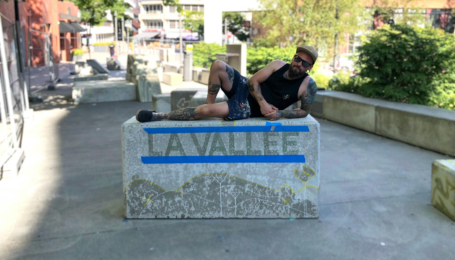 Gaël Simon, artiste peintre chez Peinture Nantaise, prend une pose sur l'un des blocs béton de la Vallée de l'Art du Déplacement.