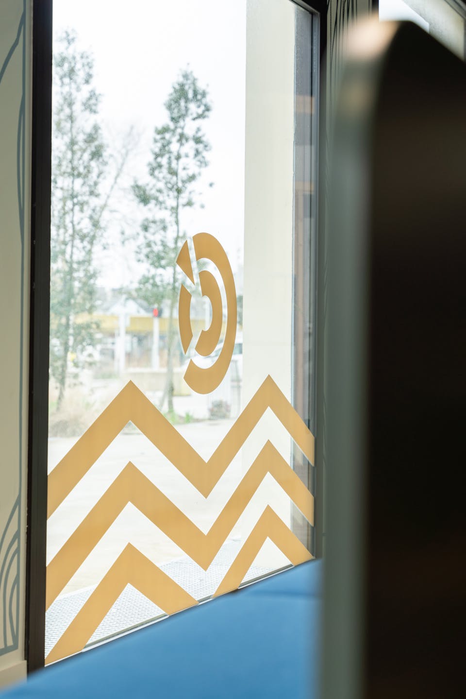 Une vitrophanie en plastique vient dessiner des vagues sur les fenêtres de la CCI Saitn-Nazaire, tout en affichant le logo de leur entreprise.