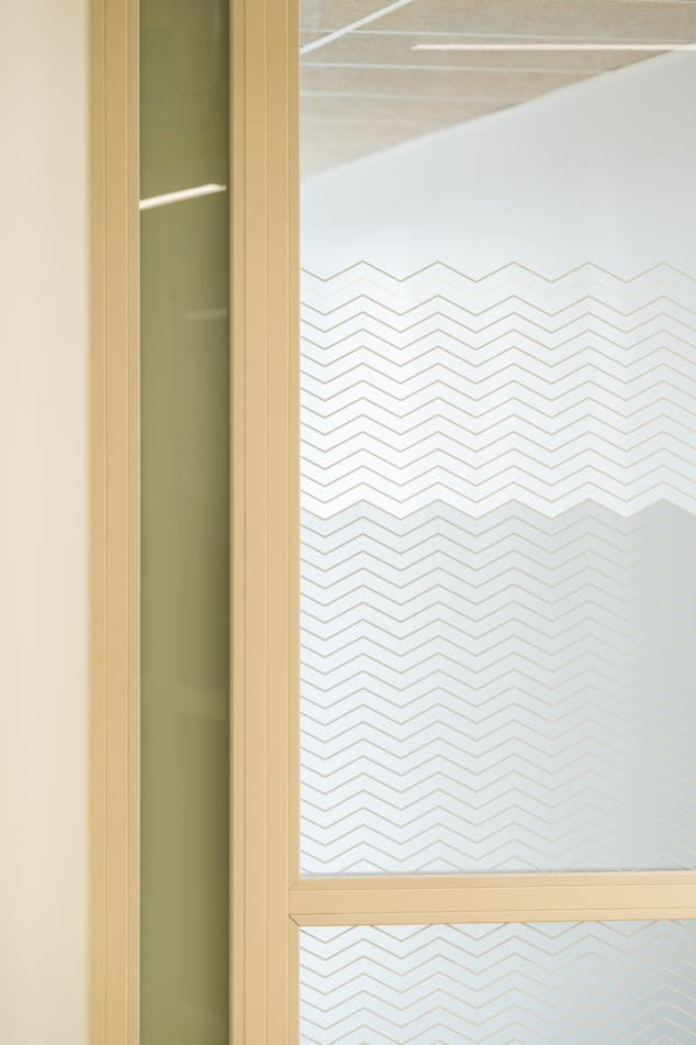 Une trame graphique en forme de vagues pointues, apposée en vitrophanie sur les vitres d'une salle de réunion durant l'aménagement de la Maison de l'Entreprise à Saint-Nazaire par l'agence de design Studio Katra.