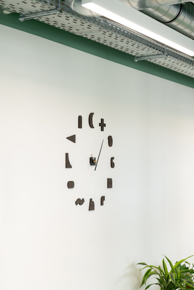 Une horloge en bois incorporant le vocabulaire de formes de la Maison de l'Entreprise, basé sur des formes géométriques.