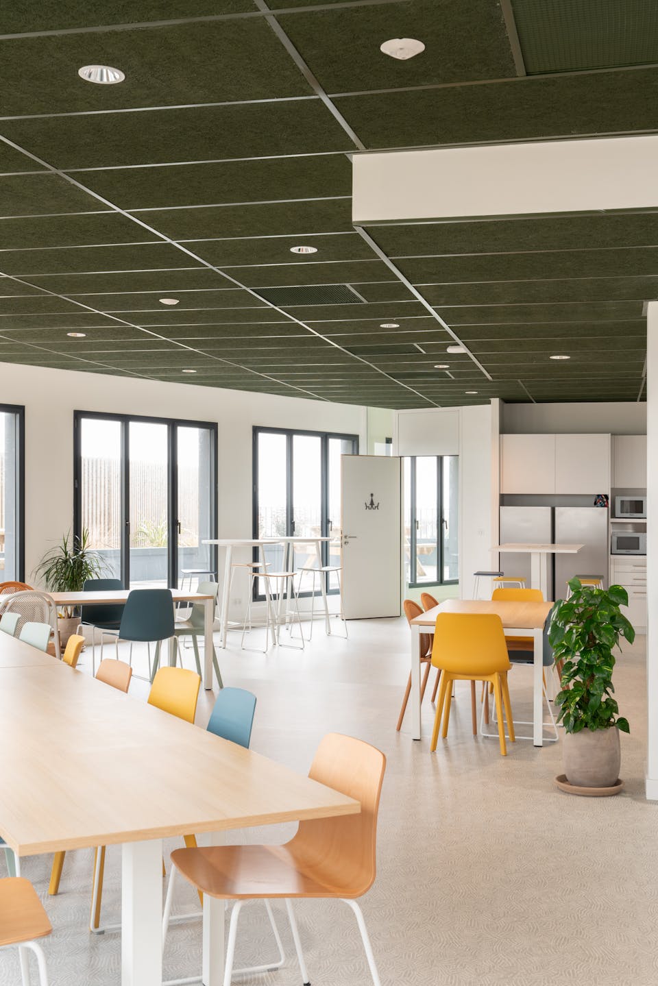 Une grande salle à manger au sein de la Maison de l'Entreprise de Saint-Nazaire, où sont logées de nombreuses tables et chaises.