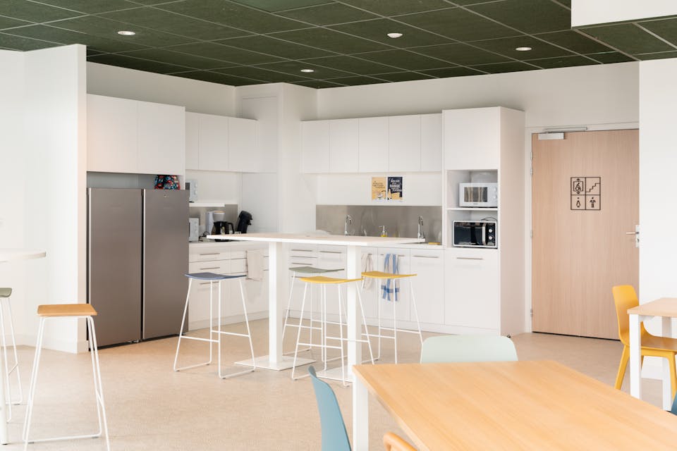 Une grande salle à manger au sein de la Maison de l'Entreprise de Saint-Nazaire, où sont logées de nombreuses tables et chaises.