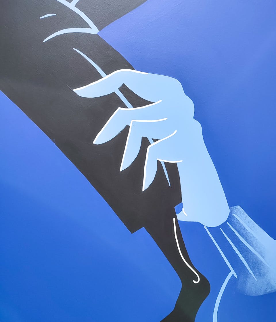 Zoom sur l'une des fresques de l'agence de design graphique Studio Katra au sein d'Intersport Paris-les-Halles, représentant une main tenant un mollet.