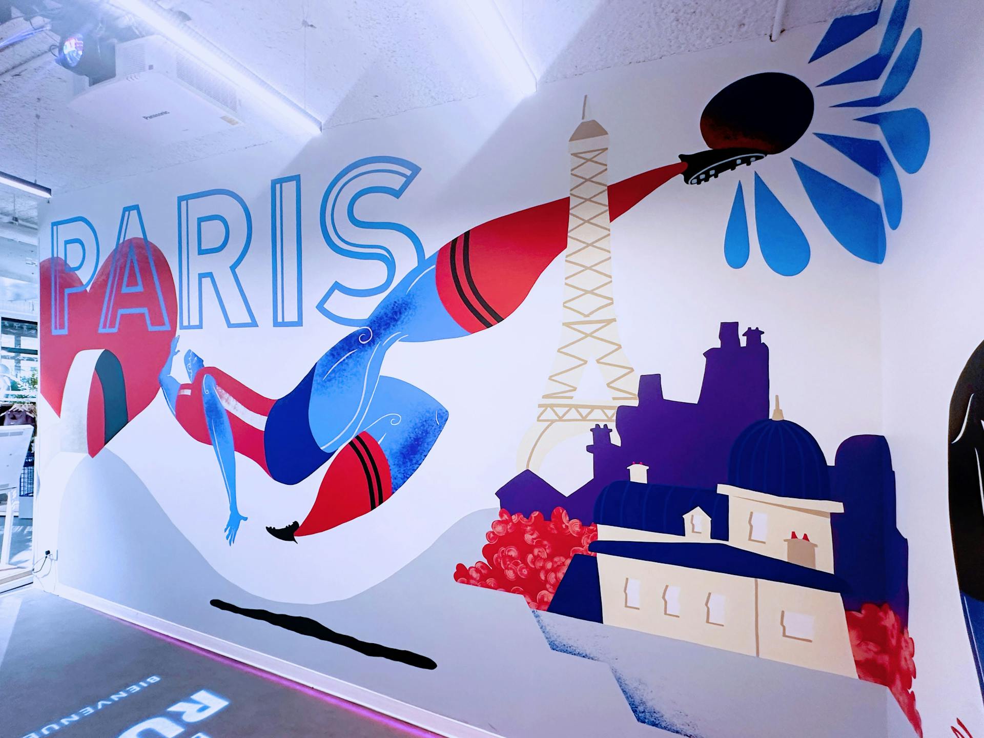 Fresque de l'agence de Design Graphique Studio Katra pour Intersport. On y voit l'inscription "Paris", une Tour Eiffel, ainsi qu'un joueur de foot effectuant une reprise de volley.