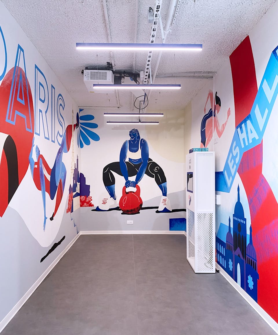 Une section de fresque réalisée par l'agence de Design graphique Studio Katra pour Intersport Paris-Les-Halles, représentant une femme soulevant un énorme poids.