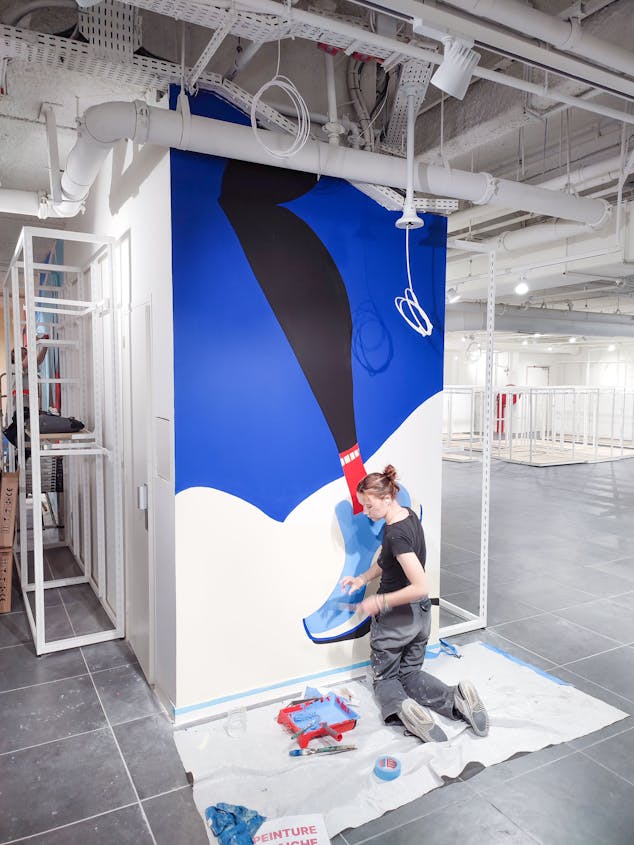 Les designers graphiques de l'agence Studio Katra, réalisant les différentes fresques murales d'Intersport Paris-les-Halles.