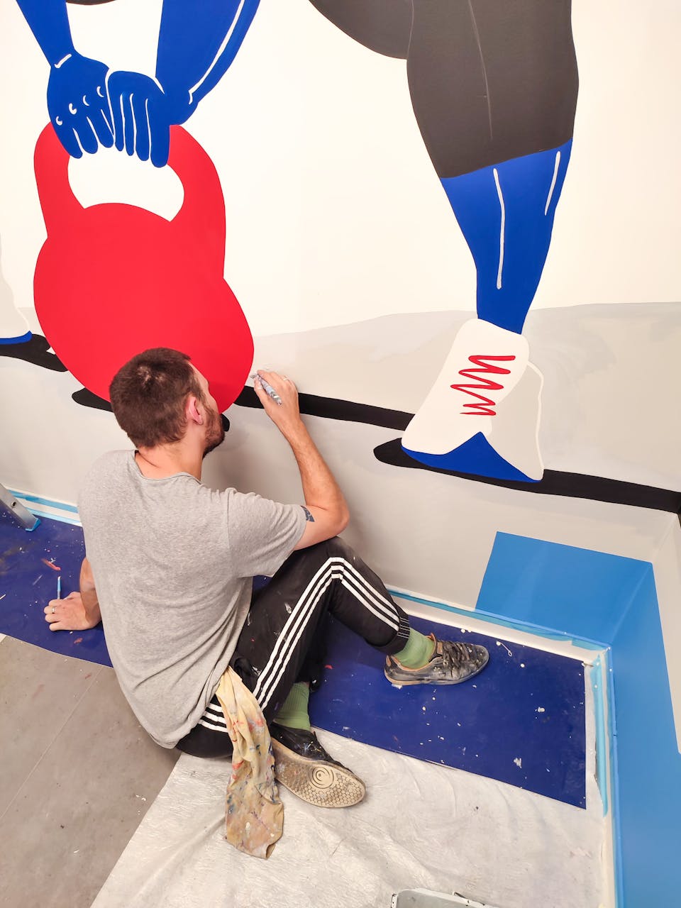 Les designers graphiques de l'agence Studio Katra, réalisant les différentes fresques murales d'Intersport Paris-les-Halles.