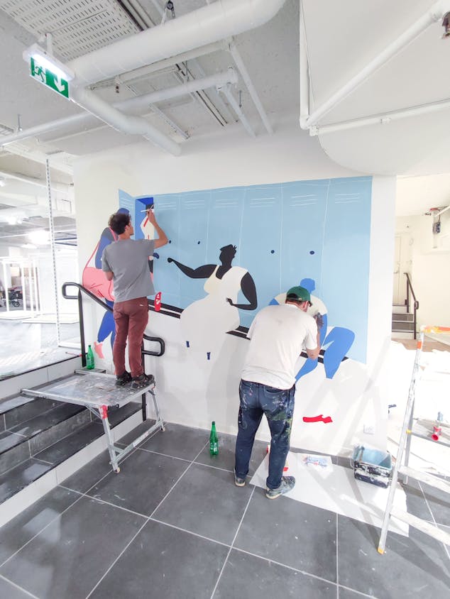 Les designers graphiques de l'agence Studio Katra, réalisant les différentes fresques murales d'Intersport Paris-les-Halles.