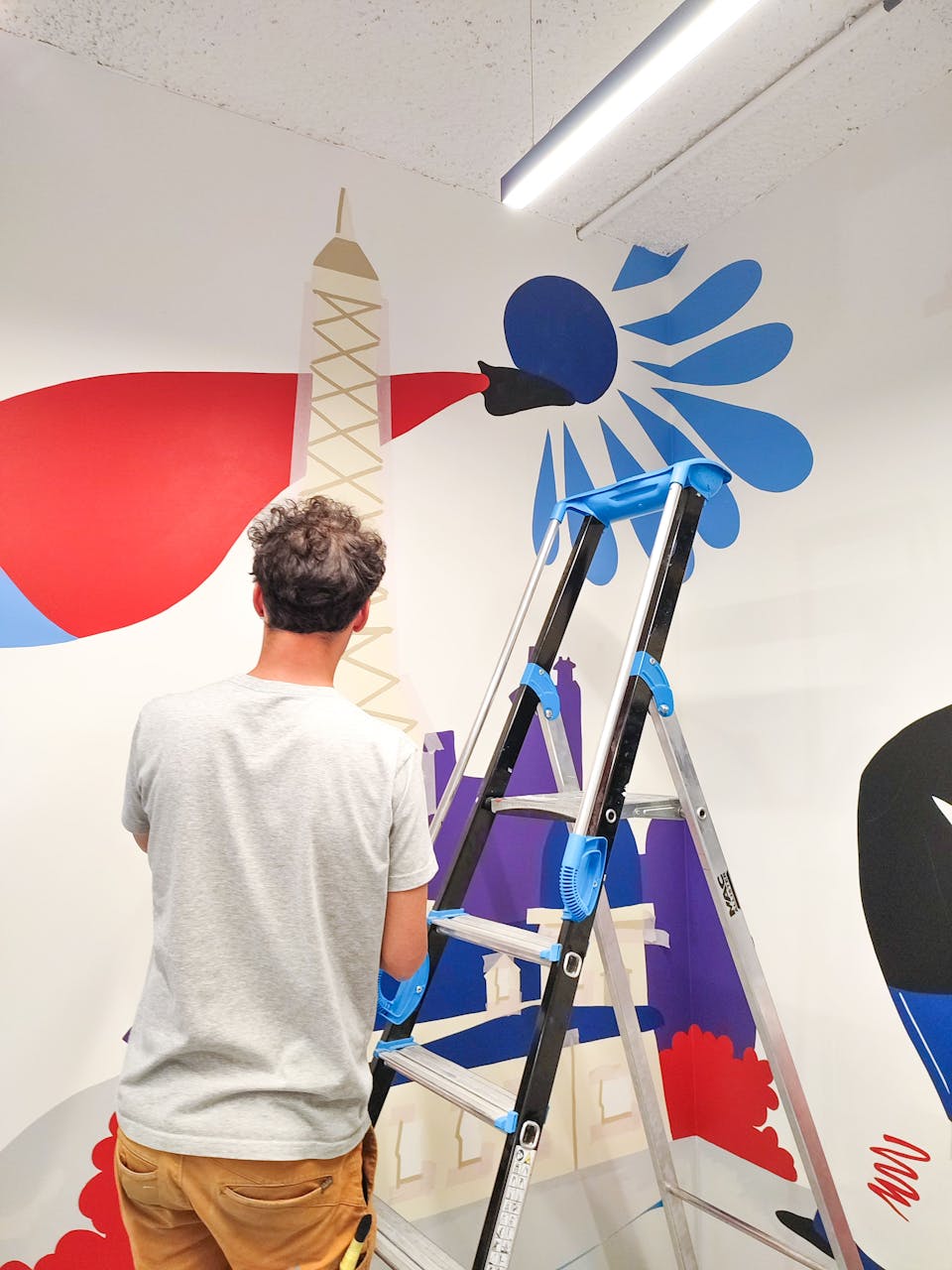 Les designers graphiques de l'agence Studio Katra, réalisant les différentes fresques murales d'Intersport Paris-les-Halles.